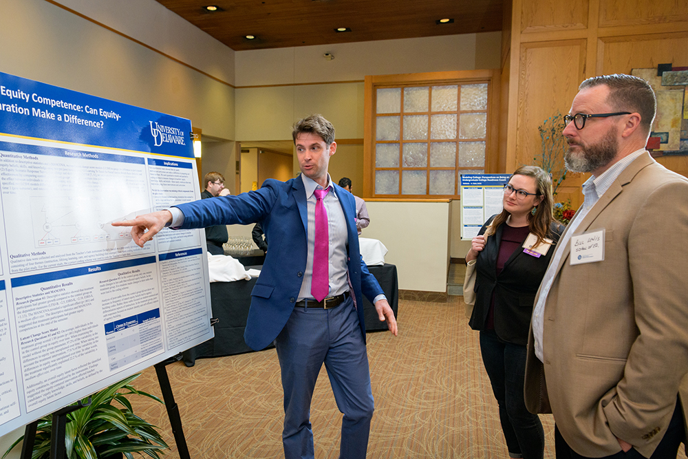 Student discusses research poster with faculty at 2019 Steele Symposium