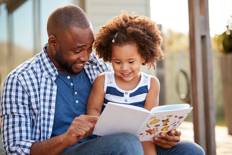 A father reads to his daughter.