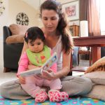 A mother enjoying quality time reading to her infant.