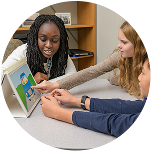 Doctoral school psychology student working with two students at the College School