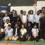 An elementary class at Warner Elementary poses for a group photo with a community police officer.
