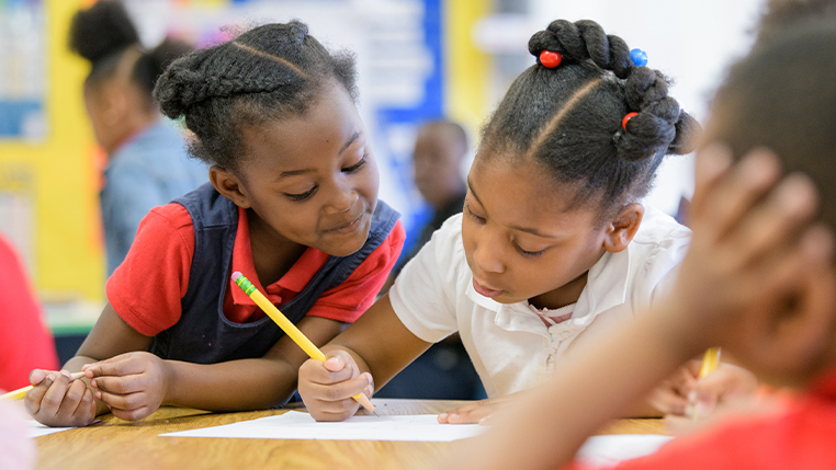 Two black female students working on an assignment in class