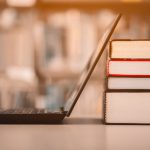 Laptop resting against a stack of books