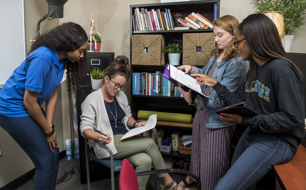 Summer Research students Khadi Jackson (royal blue shirt) and Colleen Mueller (jean jacket) are doing research Recovery Residences Effectiveness along with graduate students Jhane Campbell (black sweatshirt) and Ginnie Sawyer Morris (light blue shirt).