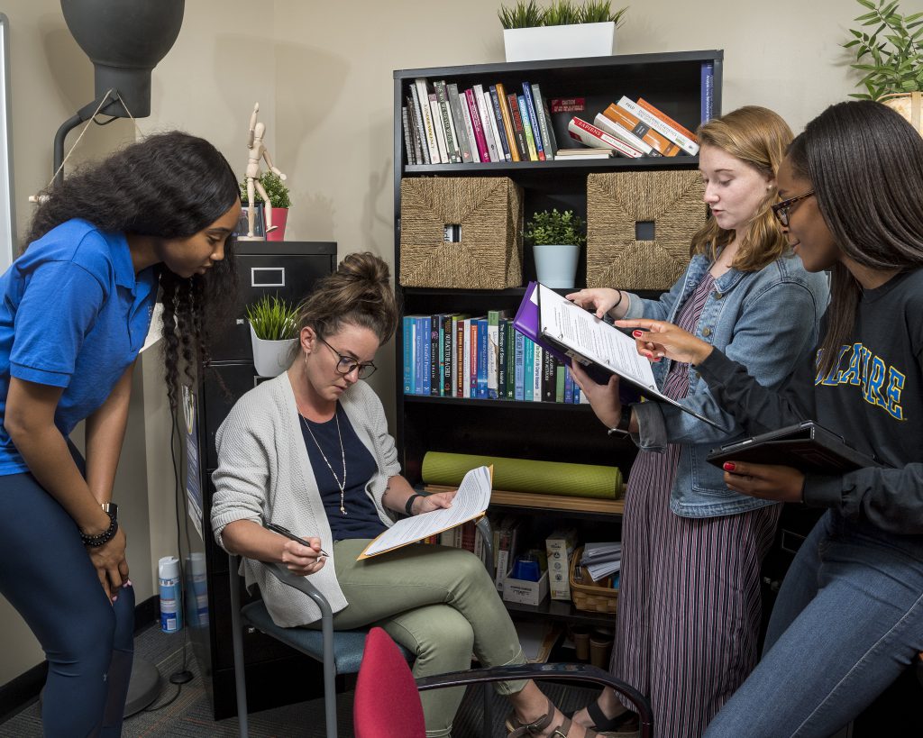 Summer Research students Khadi Jackson (royal blue shirt) and Colleen Mueller (jean jacket) are doing research Recovery Residences Effectiveness along with graduate students Jhane Campbell (black sweatshirt) and Ginnie Sawyer Morris (light blue shirt).
