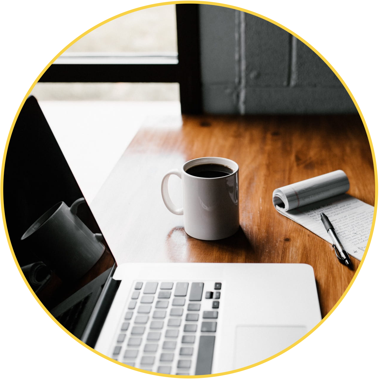 Mug, laptop, and notebook on a desk