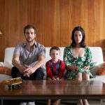 Father, mother and child sitting on couch