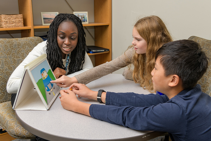 School psychology student works with two students at UD's College School