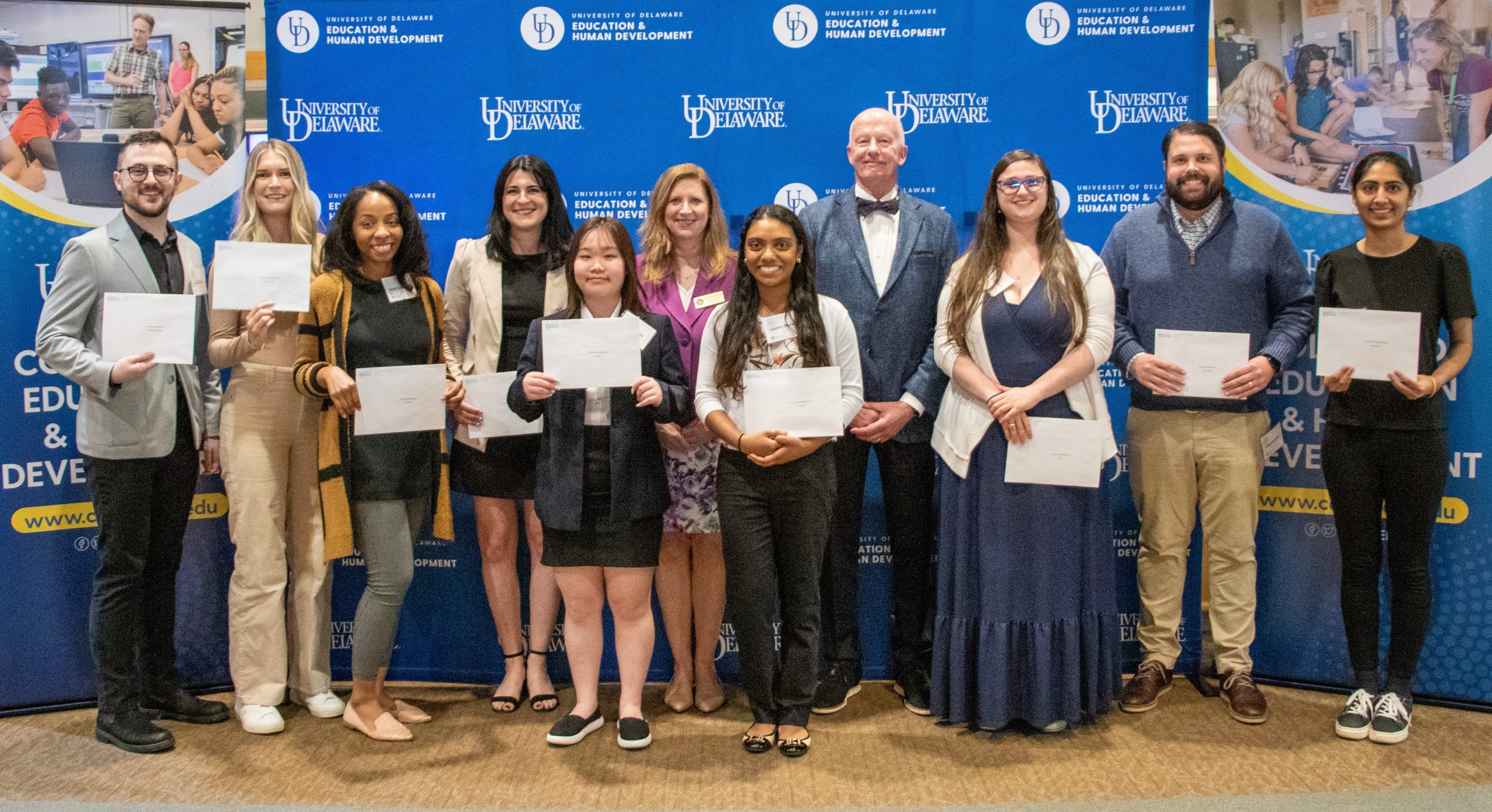 Steele award winners standing in front of UD backdrop with Dean Henry and Laura Desimone