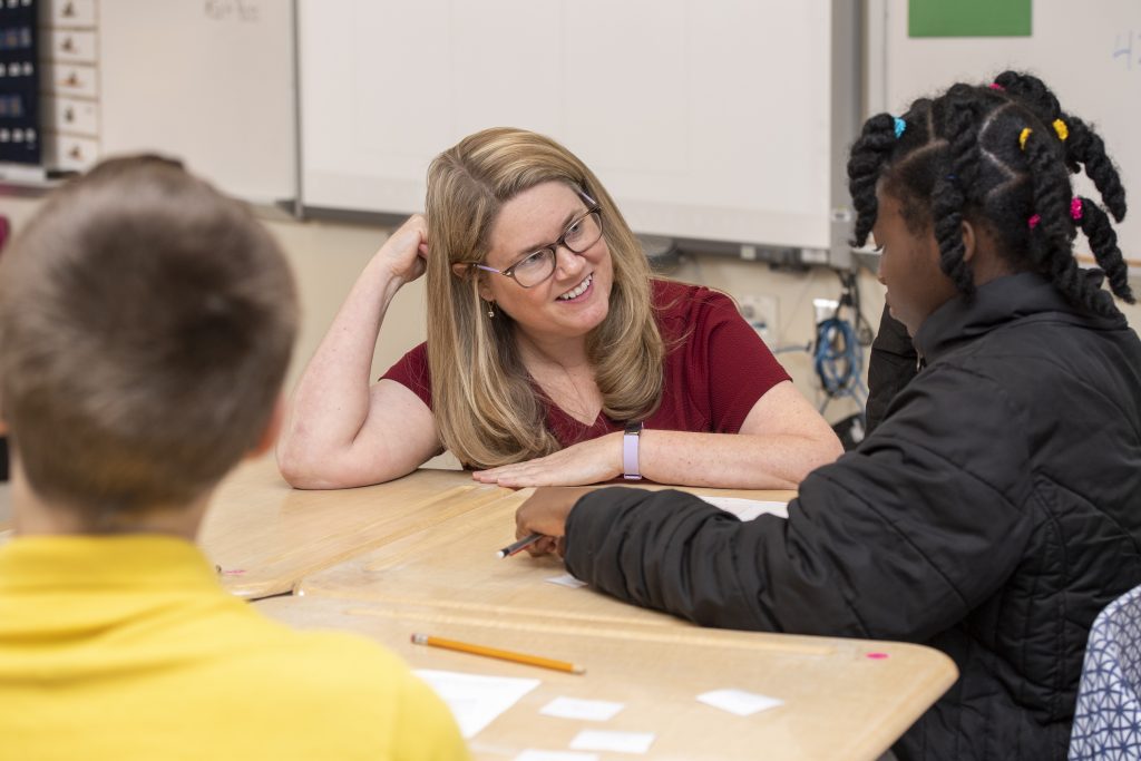 Amanda Jansen, professor in the College of Education and Human Development, works with students on a math activity at Milford Central Middle school.