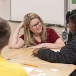 Amanda Jansen, professor in the College of Education and Human Development, works with students on a math activity at Milford Central Middle school.