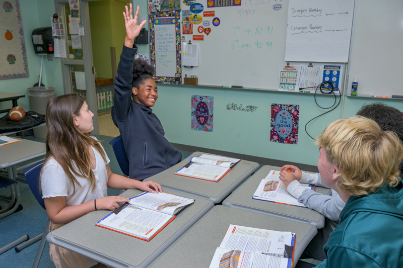 UD’s The College School specializes in teaching students with learning differences. Here, seventh grader Sanaa eagerly participates in a science lesson on divergent boundaries with classmates Katherine and Nate sharing in the group activity.