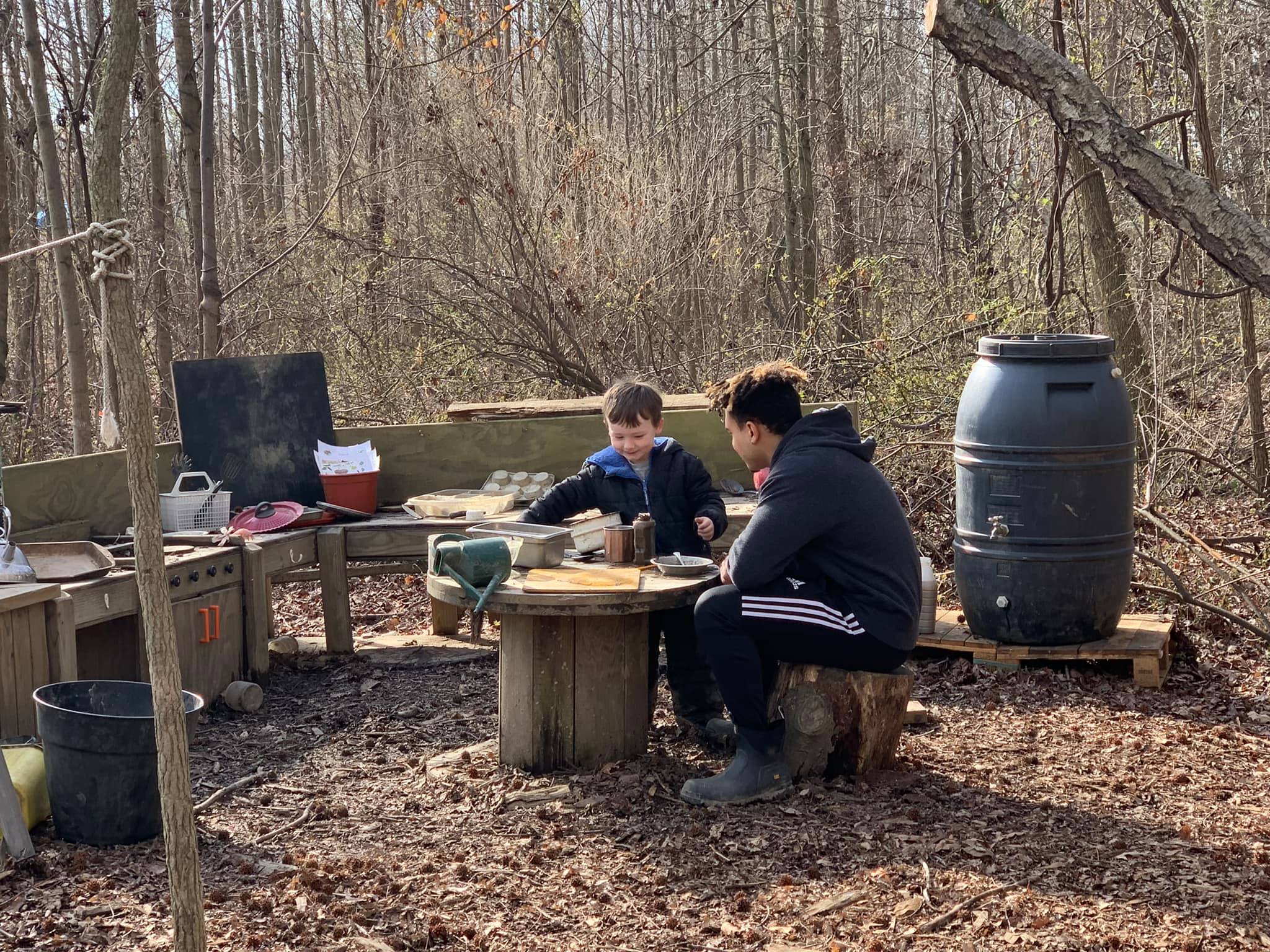 A University of Delaware student and a child interact in the Lab’s School’s outdoor mud kitchen, located on the College of Education and Human Development’s Children’s Campus.