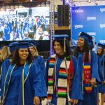 Graduates of the College of Education and Human Development and Family Sciences accept their degree and return to their seats amid cheers from the crowd.