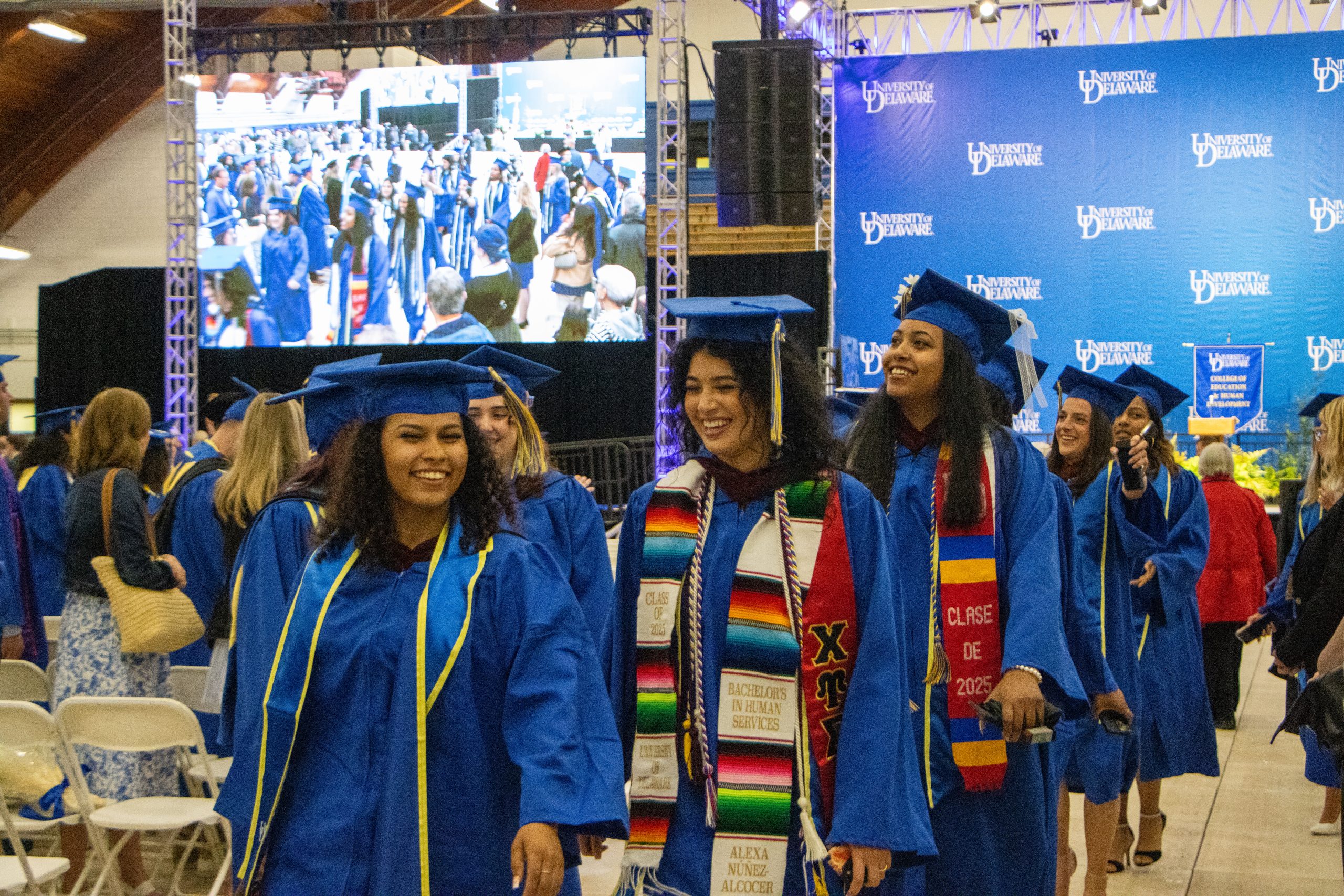 Graduates of the College of Education and Human Development and Family Sciences accept their degree and return to their seats amid cheers from the crowd.