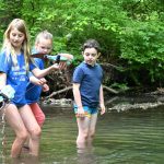 Elementary students test their aquatic robots in the creek behind University of Delaware’s The College School.