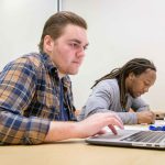 College students working on laptops.