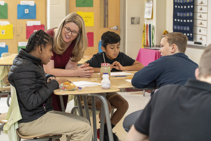 Professor Amanda Jansen works with students on a math assignment in a middle school classroom.
