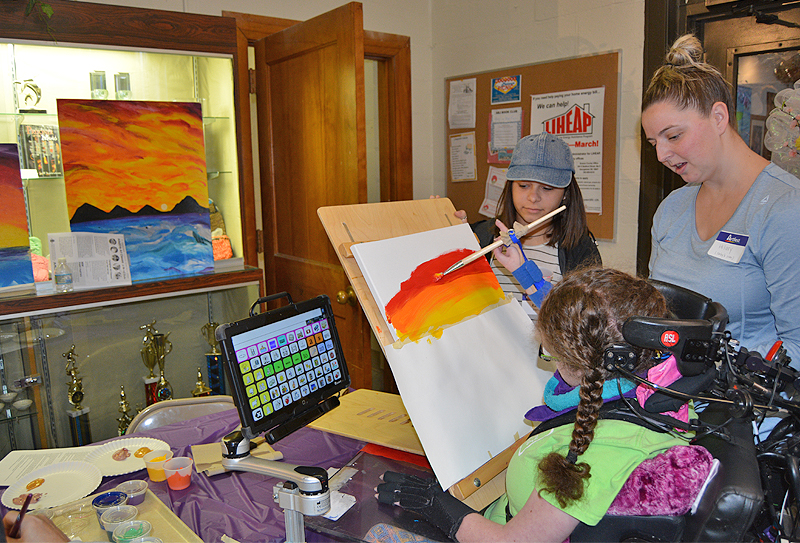 Students with disabilities often use adaptive devices to support their artistic work. Here, an ArtFest participant uses an adaptive tool during an ArtFest event. During the Center for Disabilities Studies’ training, visual and performing arts teachers learned how to support students with tools like this one and in other ways.