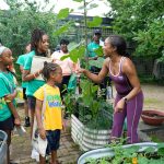 Alumna Latiaynna King (right) teaches children about plants during one of Black Girls with Green Thumbs’ educational programs.