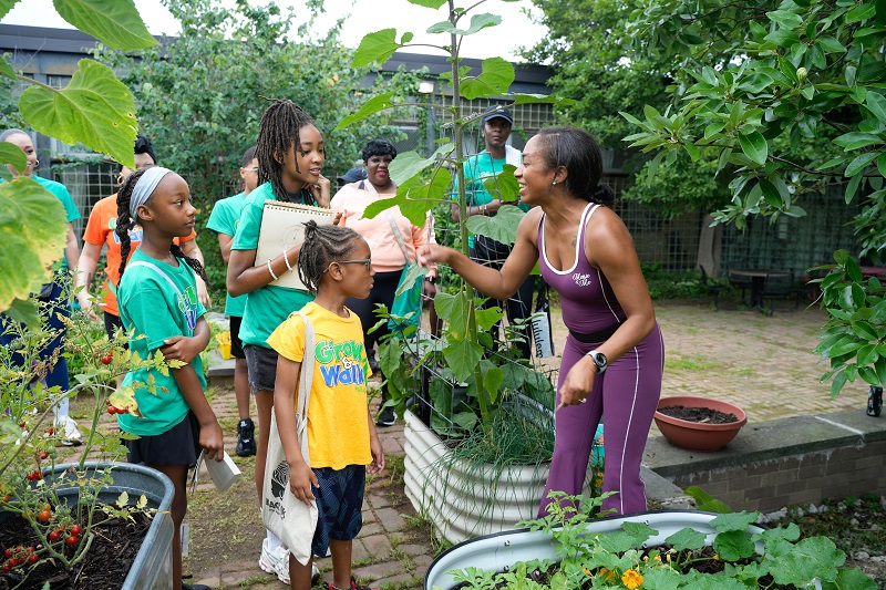 Alumna Latiaynna King (right) teaches children about plants during one of Black Girls with Green Thumbs’ educational programs.