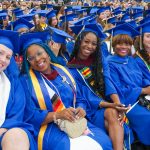 CEHD graduates, including lifelong learner Joyce Powell (third from right), wait with excitement for the moment they accept their UD degrees.