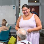 Grace DiGiacomo, a junior in the College of Education and Human Development human services program, talks with a participant at the Newark Senior Center after leading group activities in August 2026.