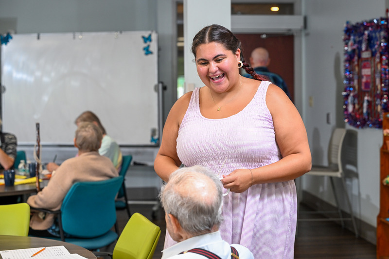 Grace DiGiacomo, a junior in the College of Education and Human Development human services program, talks with a participant at the Newark Senior Center after leading group activities in August 2026.