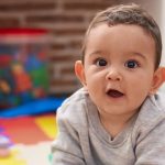 A baby plays at home.