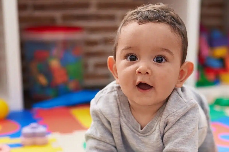 A baby plays at home.